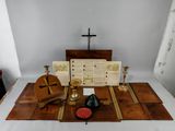 a table with a cross, a book, a candle, a bowl, and other items on it