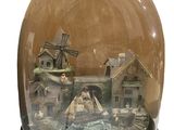 a snow globe with a house and windmill inside of it