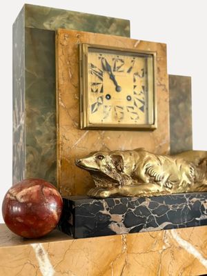 a clock and an apple sitting on a mantle