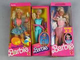 three barbie dolls are in their boxes on a white surface