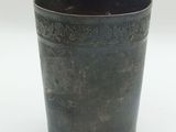 a black cup that is sitting on a white surface