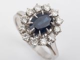 a close up of a ring with a blue sapphire surrounded by white diamonds