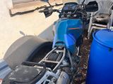 une moto garée à côté d'un fût bleu