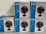 quatre boîtes de ventilateurs empilées les unes sur les autres sur une table