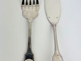 two forks and a spoon on a white table