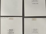four sheets of white paper with handwriting on them sitting on a table