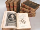 several old books sitting on top of each other on a table