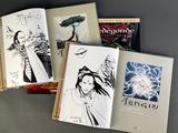several books are lined up on a table with drawings on them