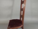 a wooden chair with a red velvet seat and back