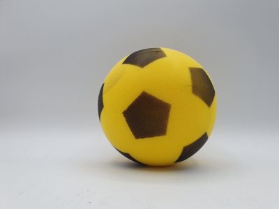 a yellow and black soccer ball on a white surface