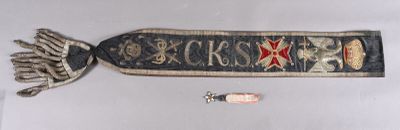 a scarf with a cross on it and some other items on the table