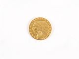 a gold coin with an indian head on it on a white surface