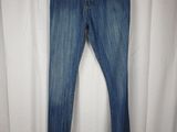 a pair of jeans hanging on a hanger in front of a white curtain