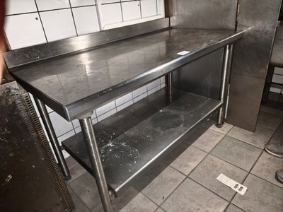 une cuisine avec un plan de travail en inox et une fenêtre