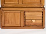 a wooden cabinet with drawers and a door on top of it