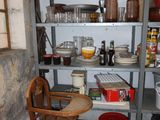 a wooden chair sitting in front of a shelf filled with dishes