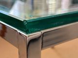 a close up of a glass table with a metal frame