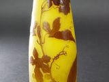 un vase jaune orné de fleurs marron, posé sur une table