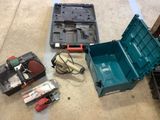 a green tool box sitting on the floor next to other tools