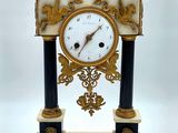 a clock that is sitting on a stand on a white background