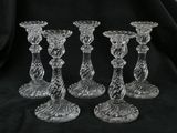 trois bougeoirs en verre transparent posés sur un tissu noir