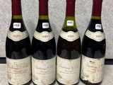 quatre bouteilles de vin sont alignées sur un comptoir