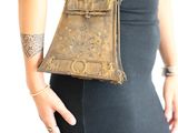 woman in a black dress holding a brown purse with a chain around it