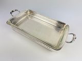 a silver tray with handles sitting on a white surface