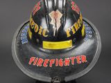 a close up of a firefighter ' s helmet on a black surface