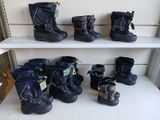 many pairs of snow boots on a shelf in a store