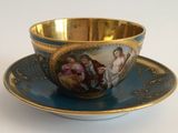 a cup and saucer with a painting on it