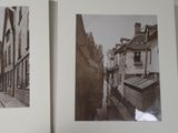 two black and white photos of a narrow street