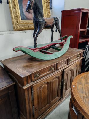 une table en bois sur laquelle est posé un cheval à bascule