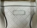 a close up of a white purse with a gold zipper