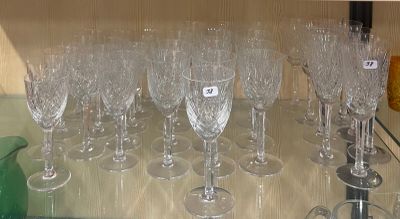 de nombreux verres à vin posés sur une étagère en verre dans la cuisine