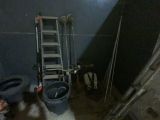 une photo d'une salle de bains avec une échelle à côté des toilettes