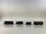 trois petits trains miniatures posés sur une surface blanche, avec un fond blanc