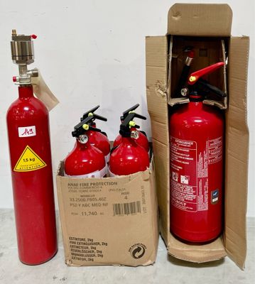 trois extincteurs dans une boîte posée à côté d'un carton