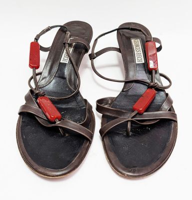 une paire de sandales noires et rouges avec des lanières rouges sur un fond blanc