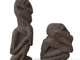 trois statues en pierre représentant un homme et une femme sur fond blanc