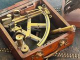 a wooden box with a brass compass inside of it