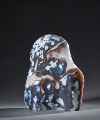 un gros plan d'un rocher bleu et blanc sur une surface grise