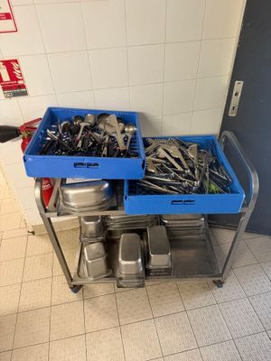 two trays of tools sitting on a metal cart