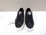 black and white sneakers with white soles on a white surface
