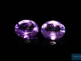 a pair of purple amethtites on a black background