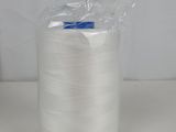 a spool of white thread sitting on top of a white table