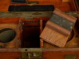 an old wooden box with a knife and other items in it