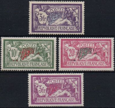 a group of four different colored stamps on a black surface