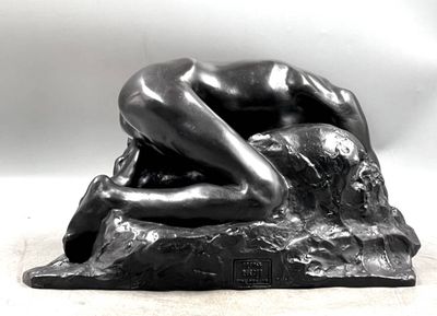 statue of a woman laying down on a rock with her hands on her head