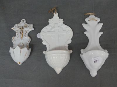 three white vases are hanging on the wall with a rope